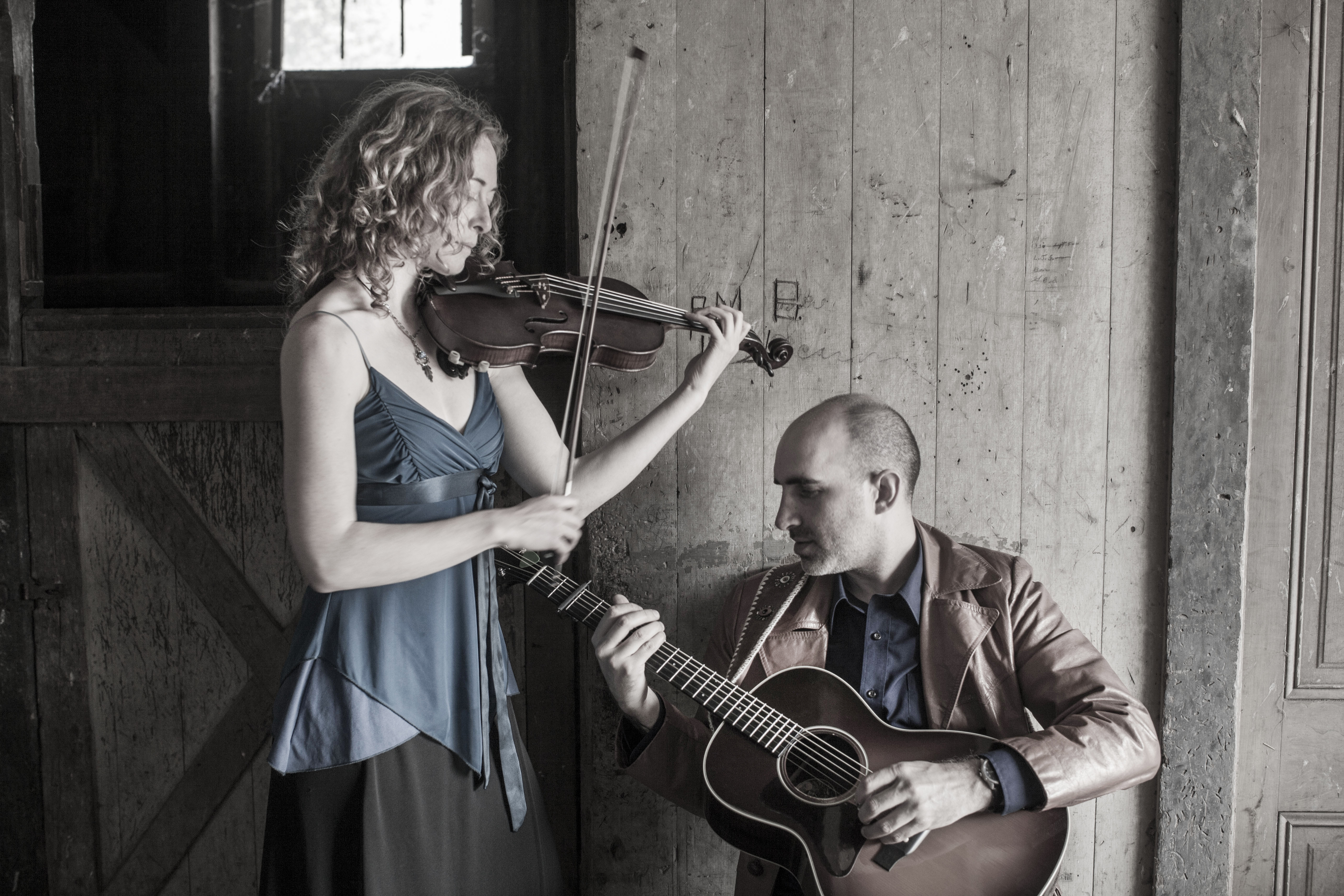 Dan Frechette & Laurel Thomsen playing their instruments in a barn