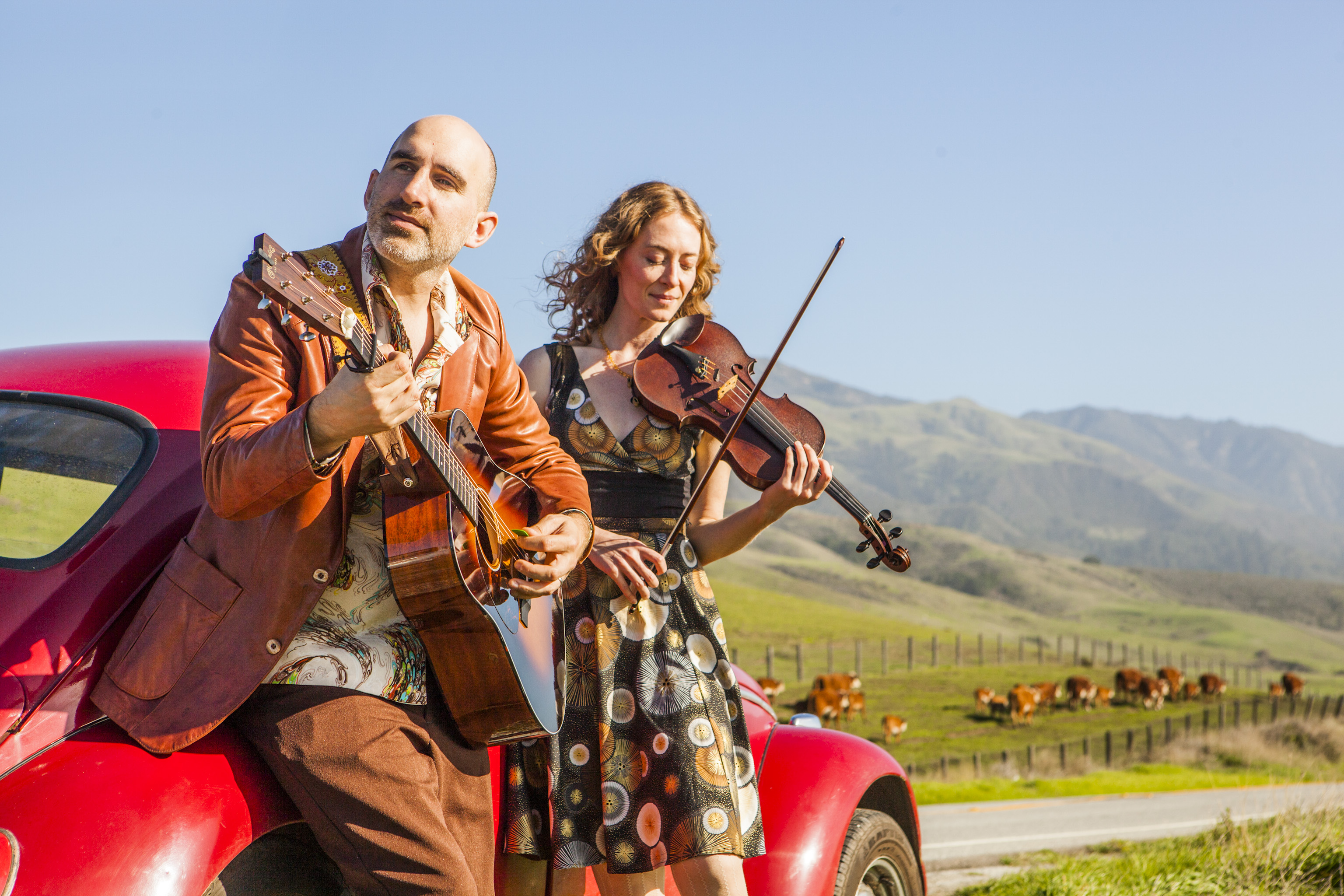 Dan Frechette & Laurel Thomsen with a red car and cows