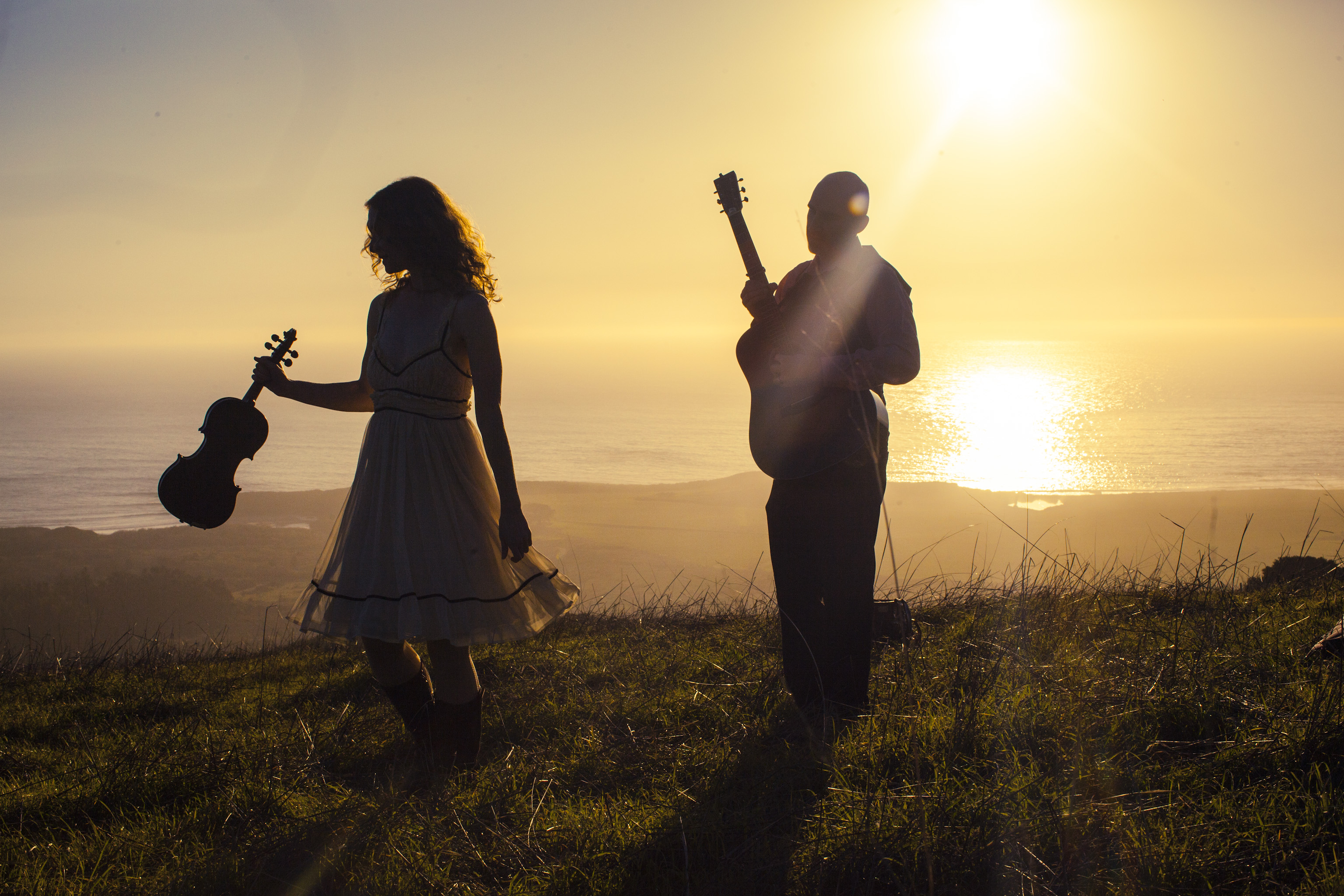 Dan Frechette & Laurel Thomsen dancing in the sunset light with their violin and guitar