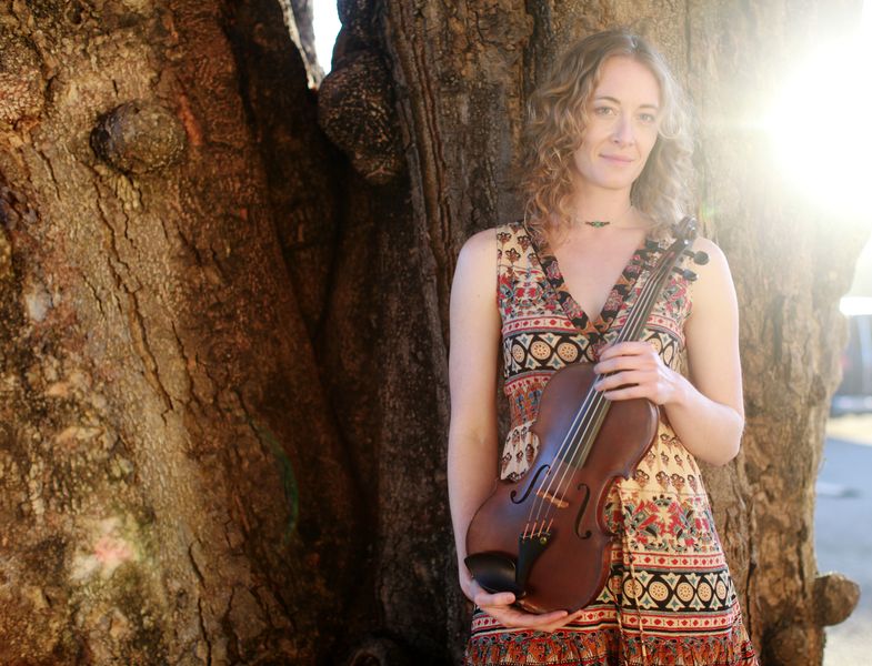 Violinist Laurel Thomsen infront of a tree