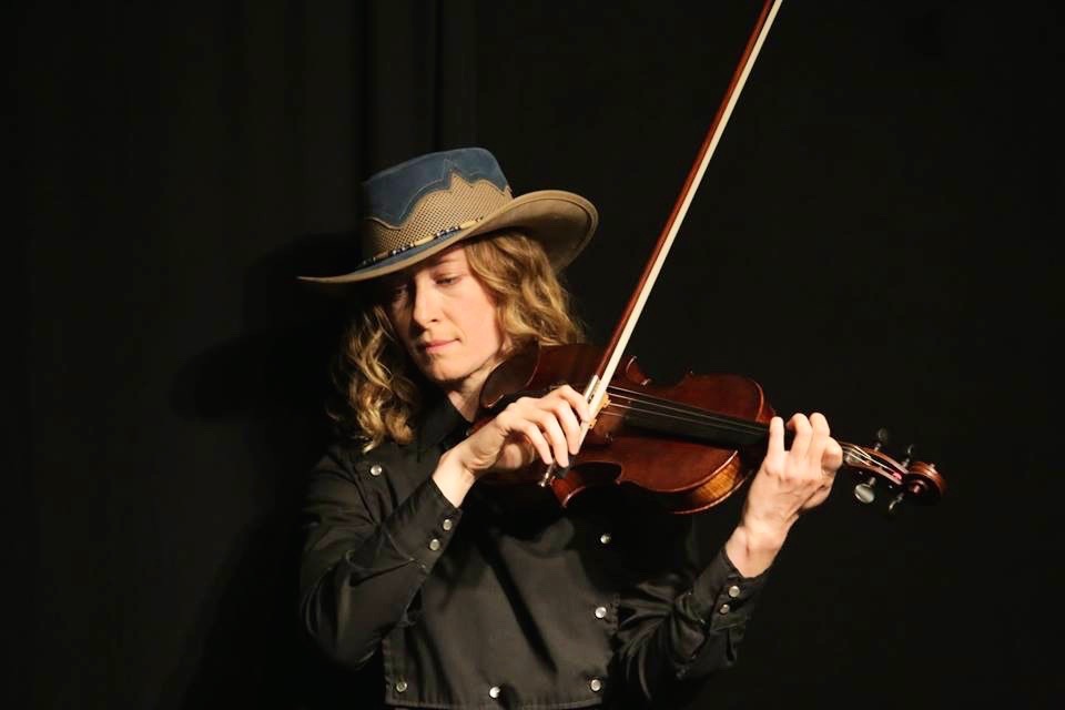 Violinist Laurel Thomsen performing in a cowboy hat at a Hank Williams tribute concert