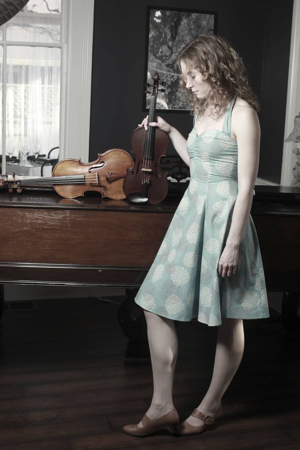 Laurel Thomsen with her violin and viola infront of a piano
