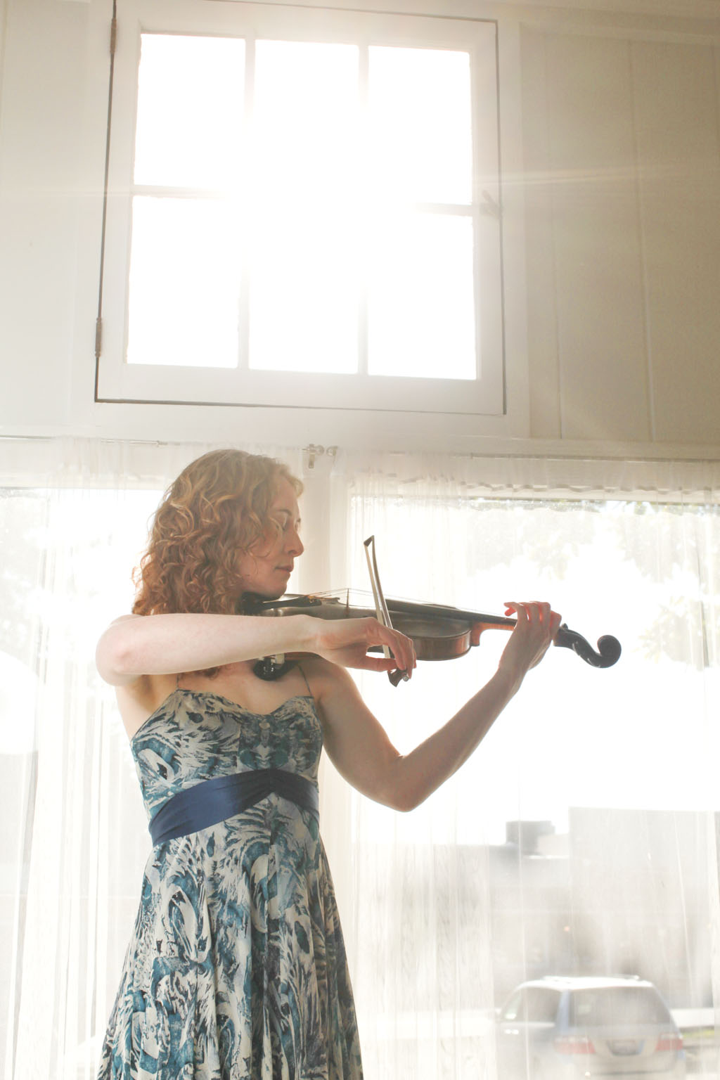 Violinist Laurel Thomsen performing infront of a bright window